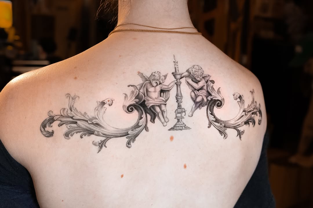 Cherubs and baroque scrollwork with candelabra realism tattoo on the back by Mateo