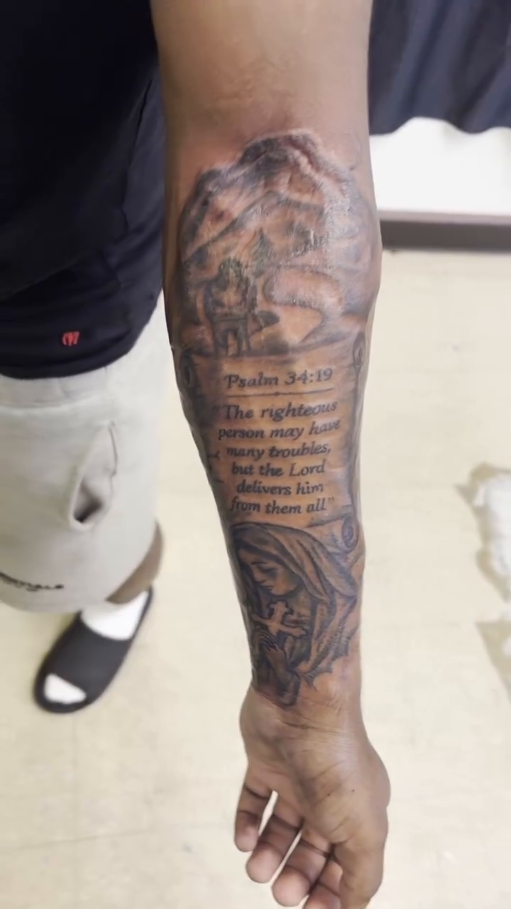 Religious text and imagery on forearm Chicano tattoo on the upper arm by Exotic Motion🌪️