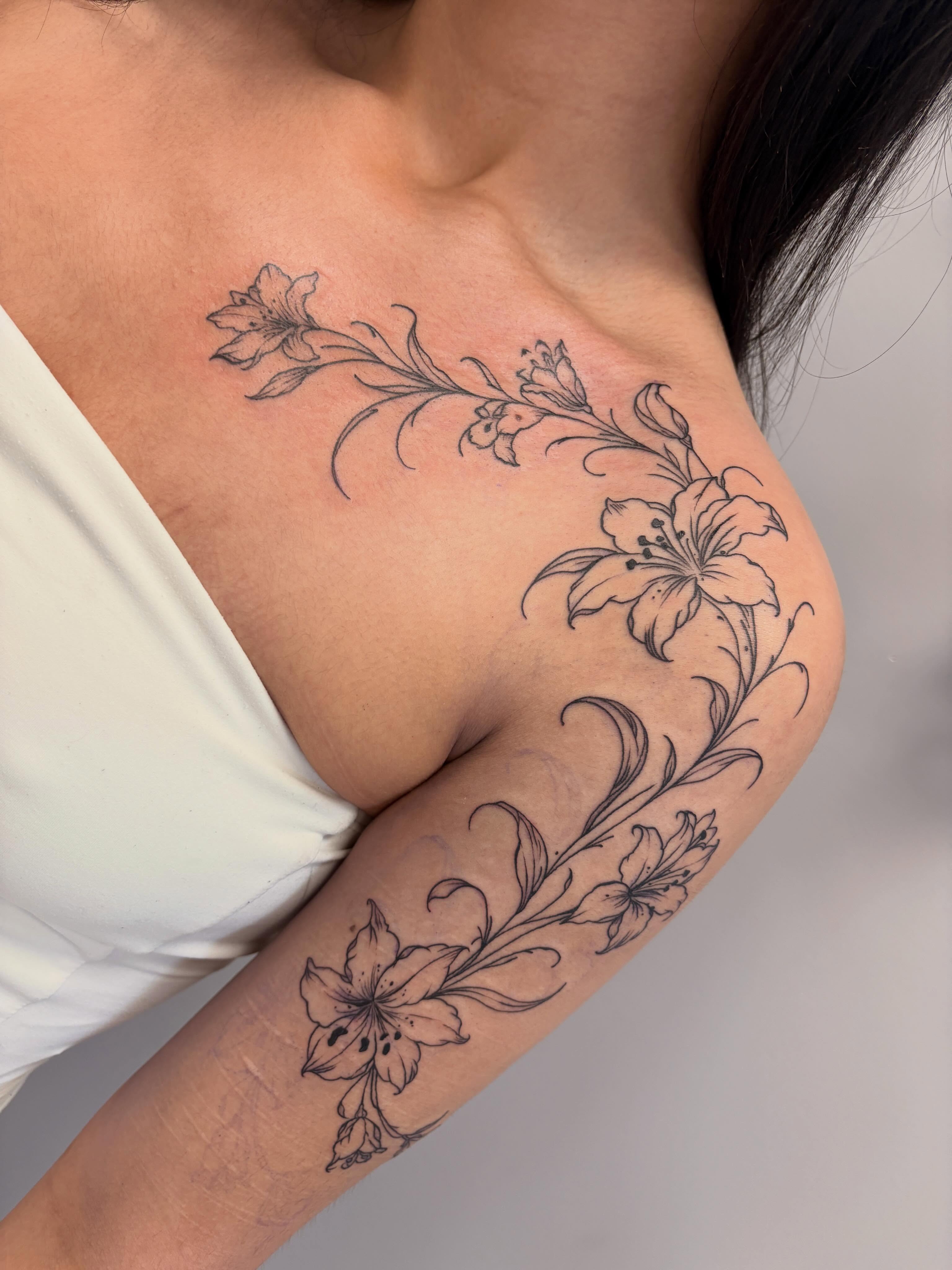 Lily flowers black and grey tattoo on the shoulder by fran! ๐ฆ edmonton artist