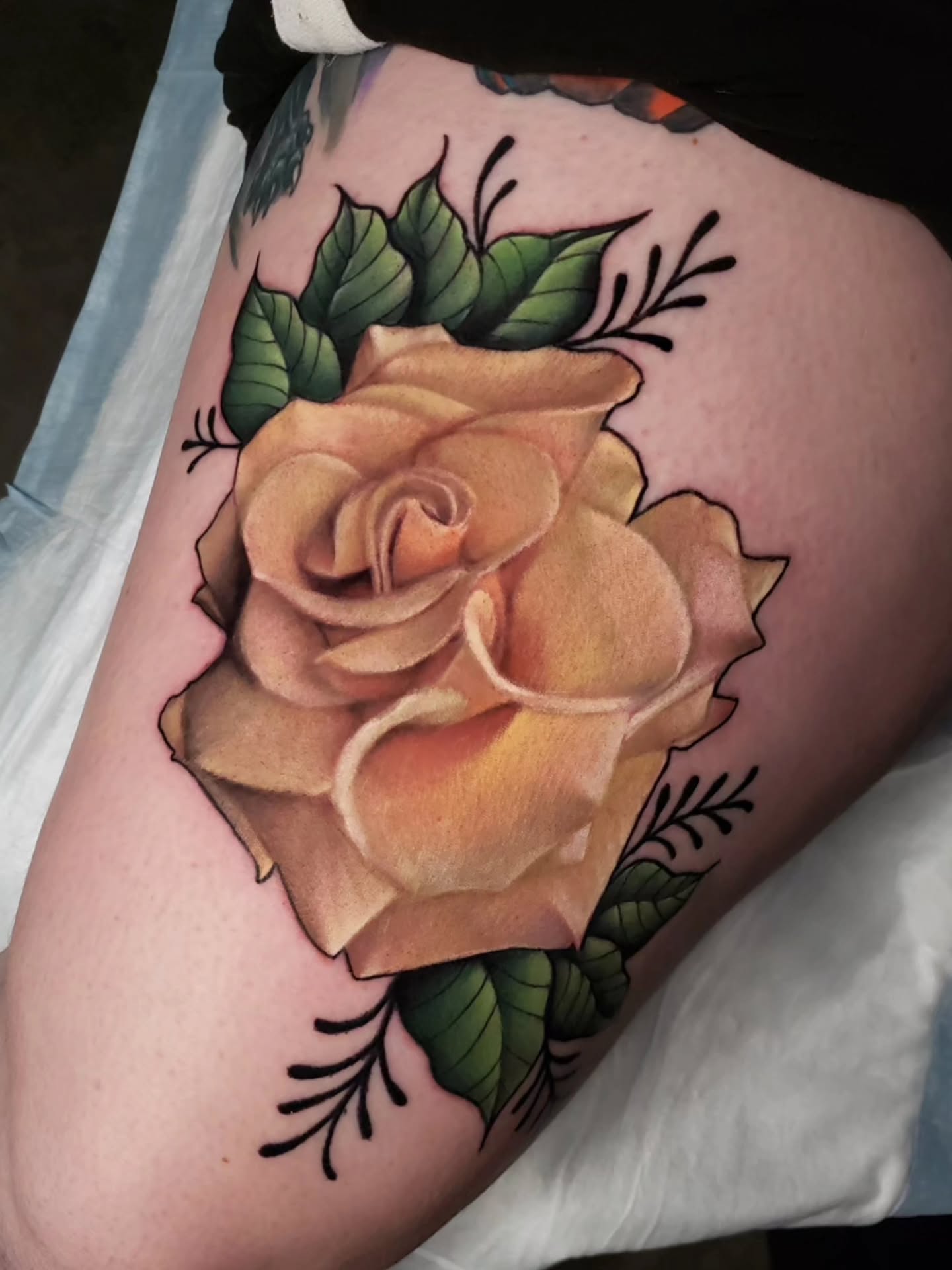 Rose American traditional tattoo on the thigh by Katie Palmer
