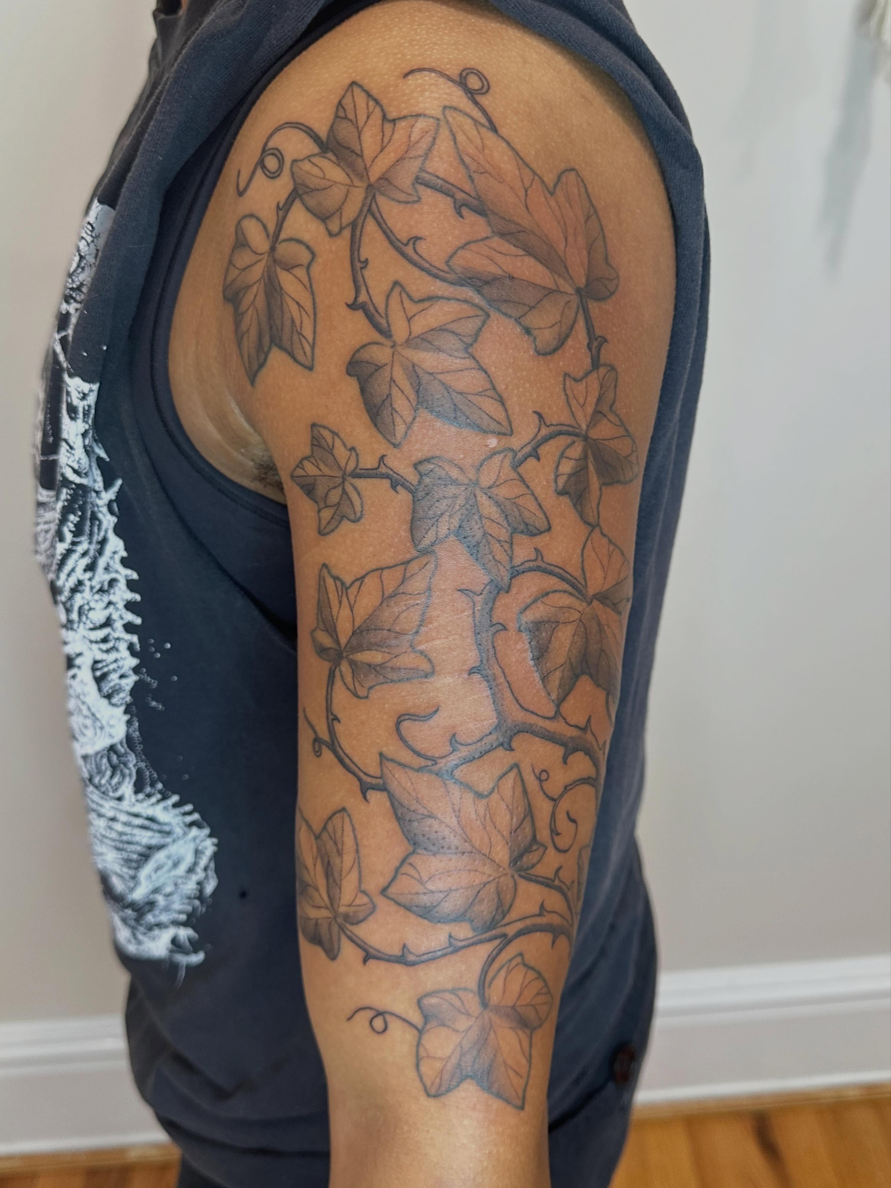 Ivy vines black and grey tattoo on the upper arm by Micha Sol