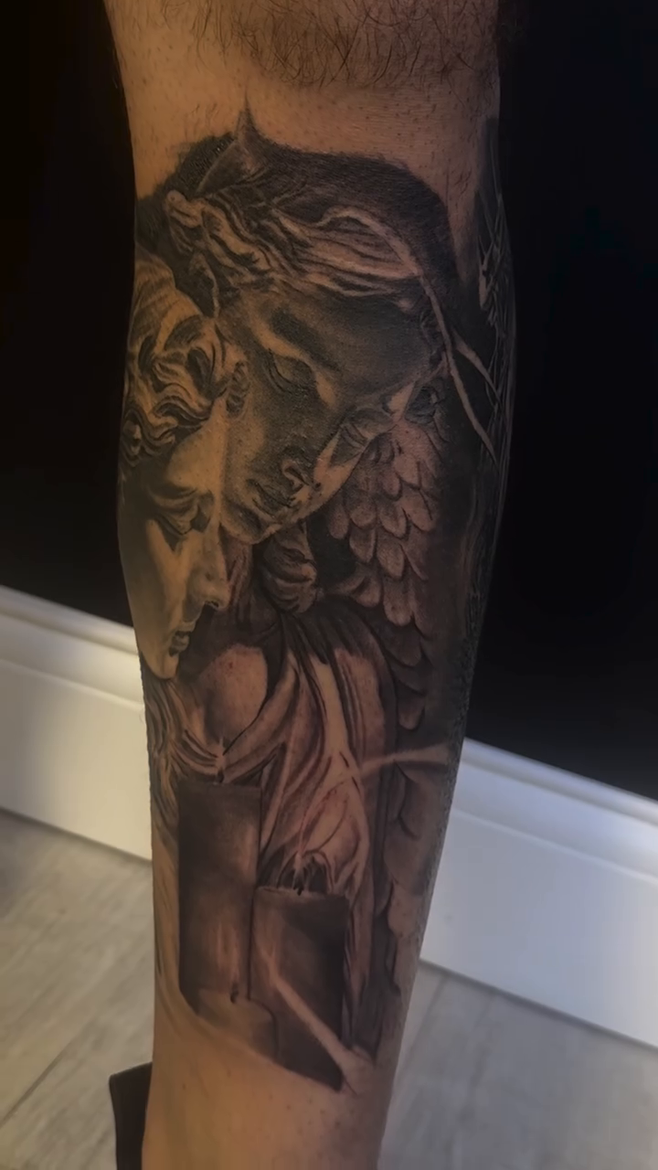 Statue of a woman with wings realism tattoo on the forearm by Eric RudeInk