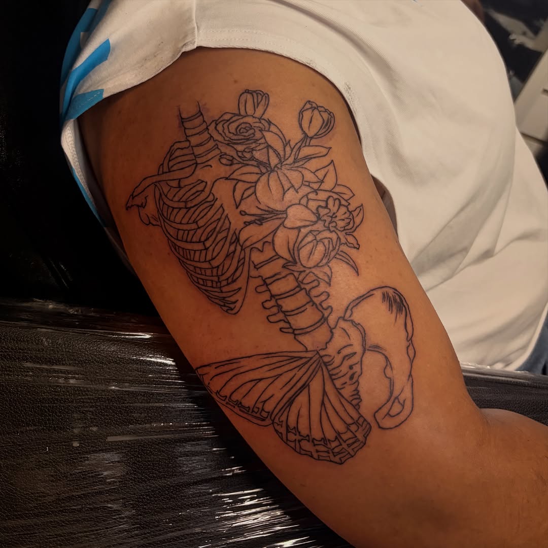 Skeleton with flowers and butterfly fine line tattoo on the thigh by Female Cleveland Tat Artist ๐