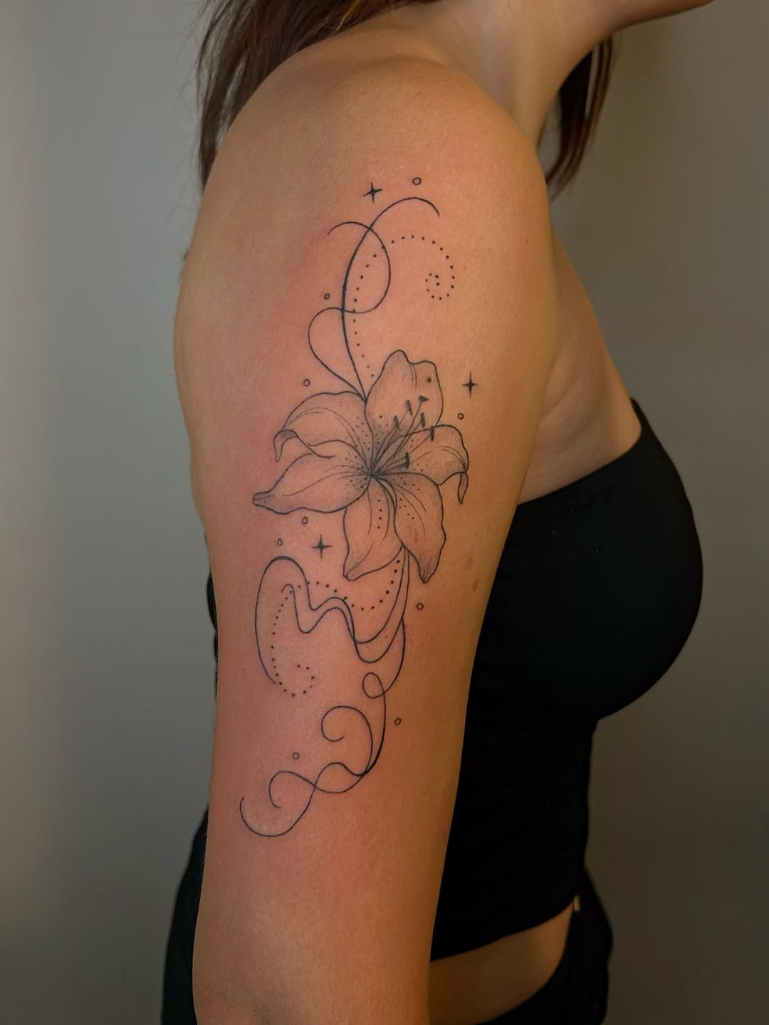 Lily flower with swirls fine line tattoo on the upper arm by 𝒜𝓇𝓉𝒾𝓈𝓉 𝒟𝒶𝒾𝓈𝓎 ♡