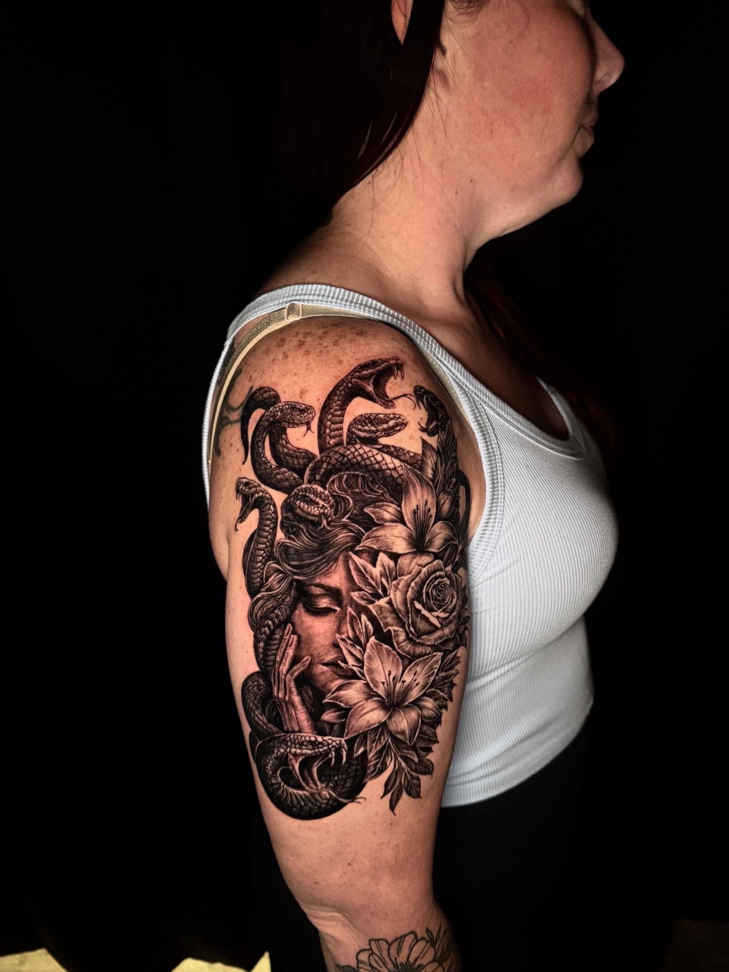 Woman with snakes and flowers realism tattoo on the shoulder by Lord Daniel Serna