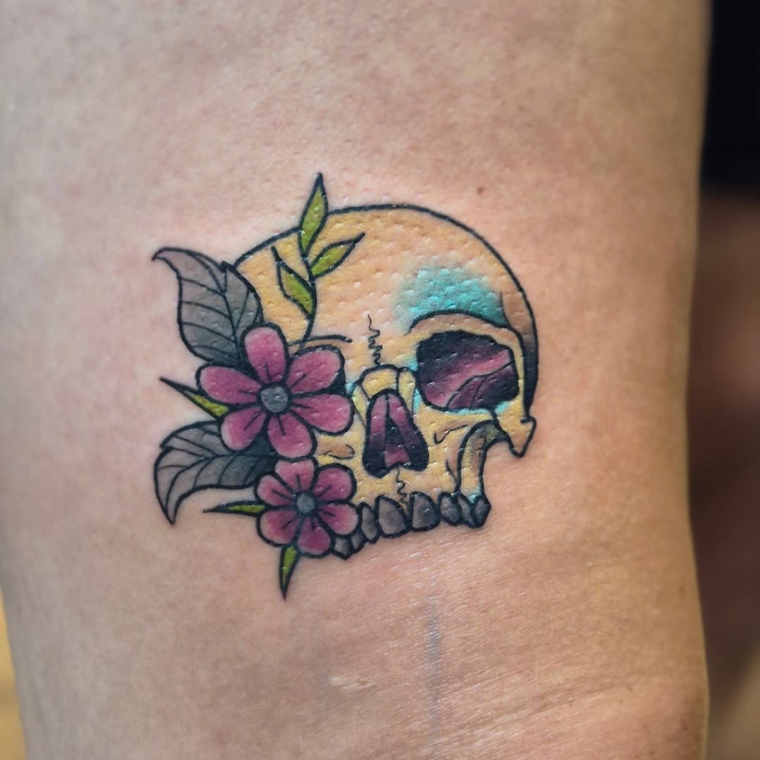 Skull with flowers American traditional tattoo on the forearm by Bobby H