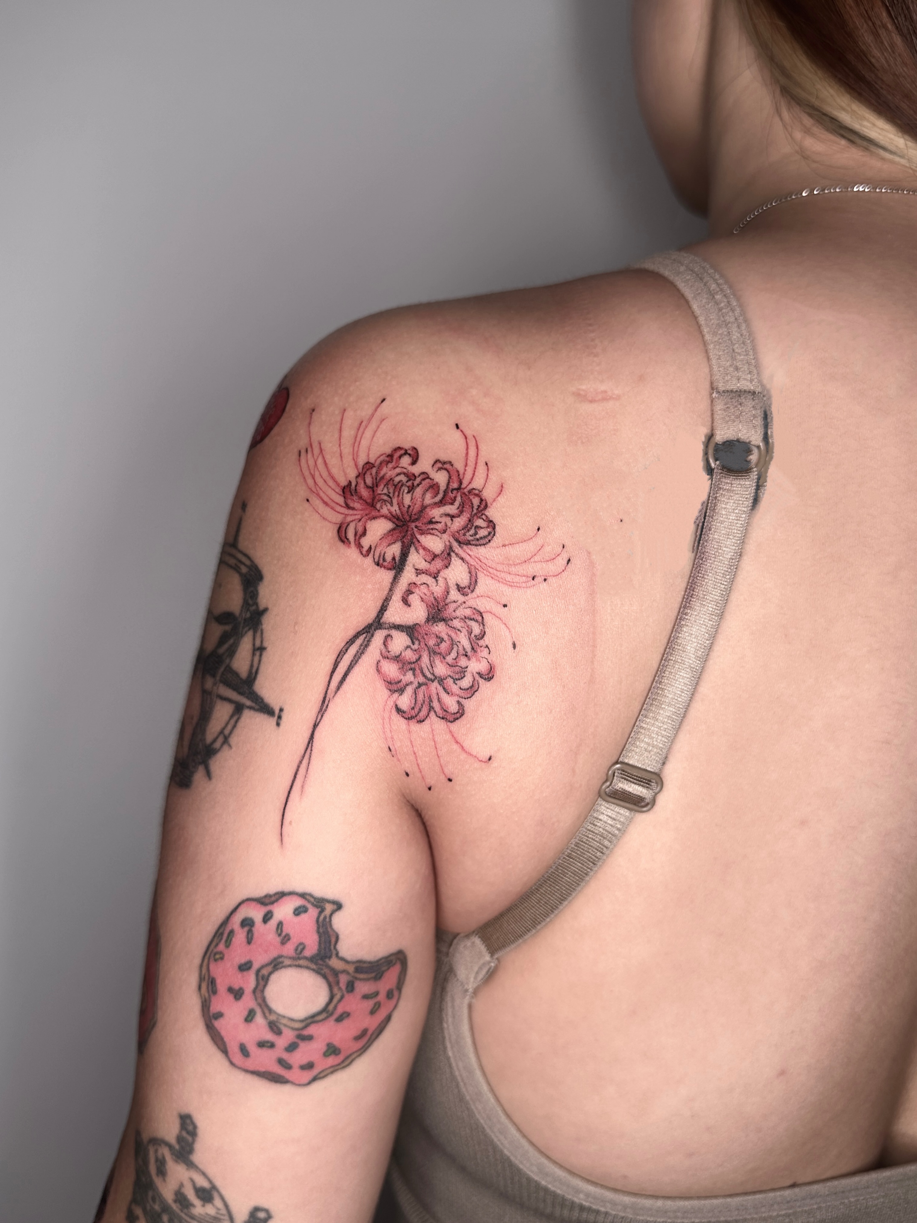 Donut and flower dotwork tattoo on the shoulder by Zecember