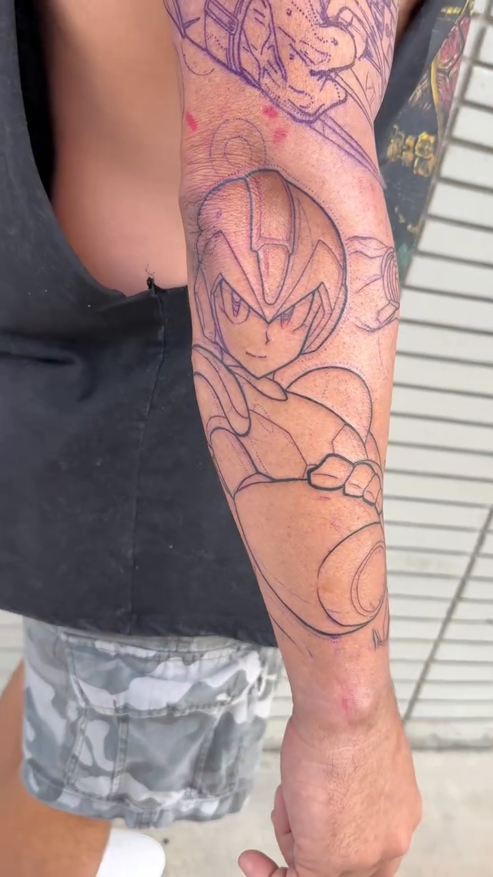 Mega Man character anime tattoo on the upper arm by Michael Bogle