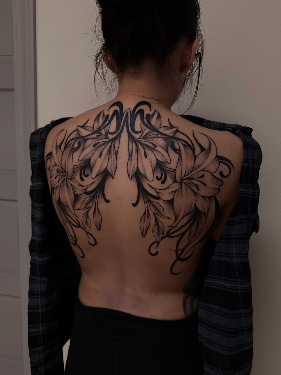 Lilies and ornamental swirls blackwork tattoo on the back by Nadia ★