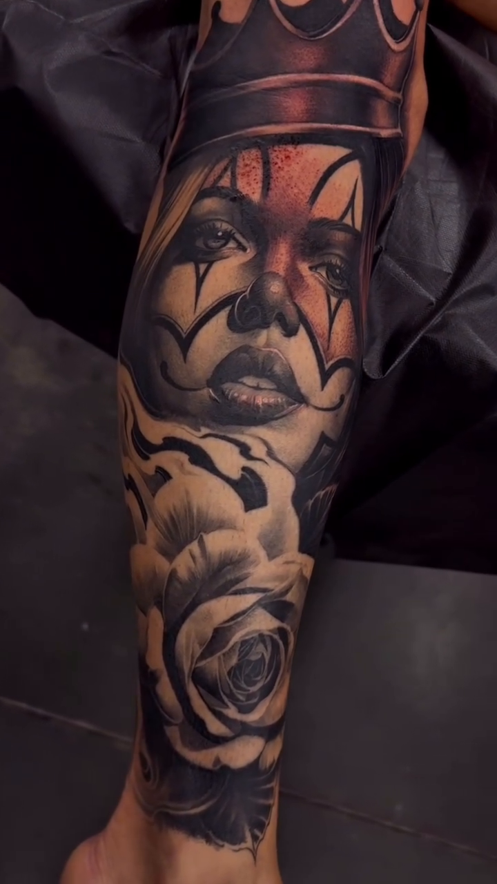 Clown face with crown and roses realism tattoo on the forearm by Dillinger, Ventura, California