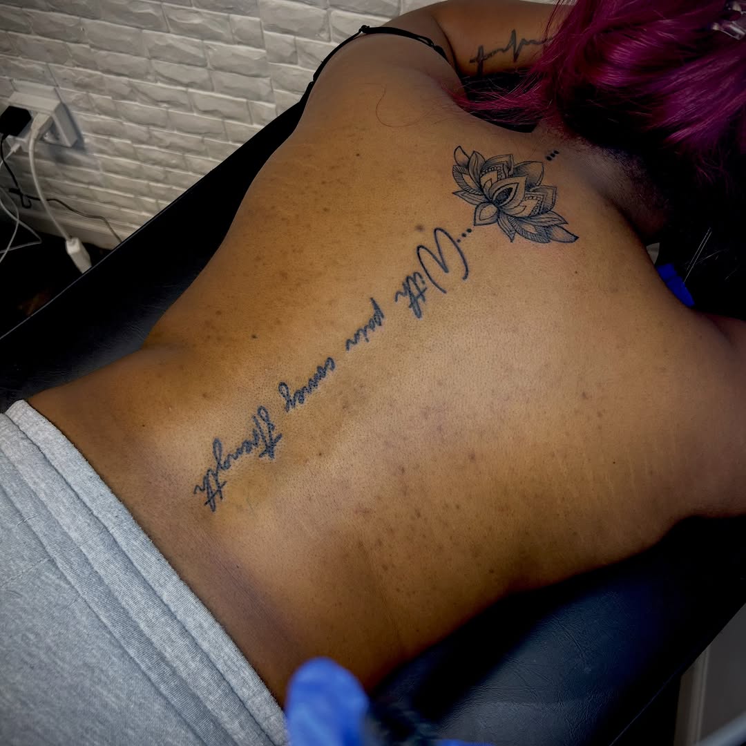 Lotus flower and script lettering tattoo on the back by Still Standing. Still Creating. 🖤