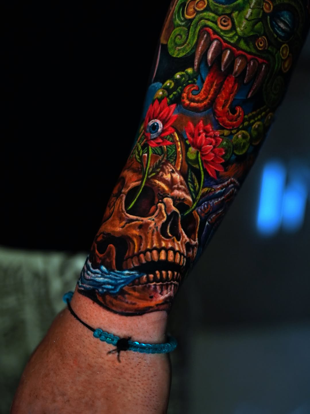 Skull with flowers and dragon surrealism tattoo on the forearm by Alberto M