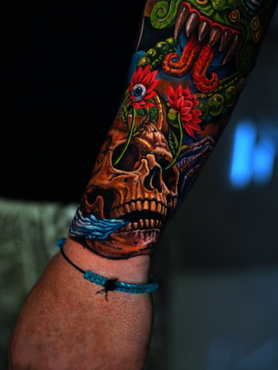 Skull with flowers and dragon surrealism tattoo on the forearm by Alberto Marrero