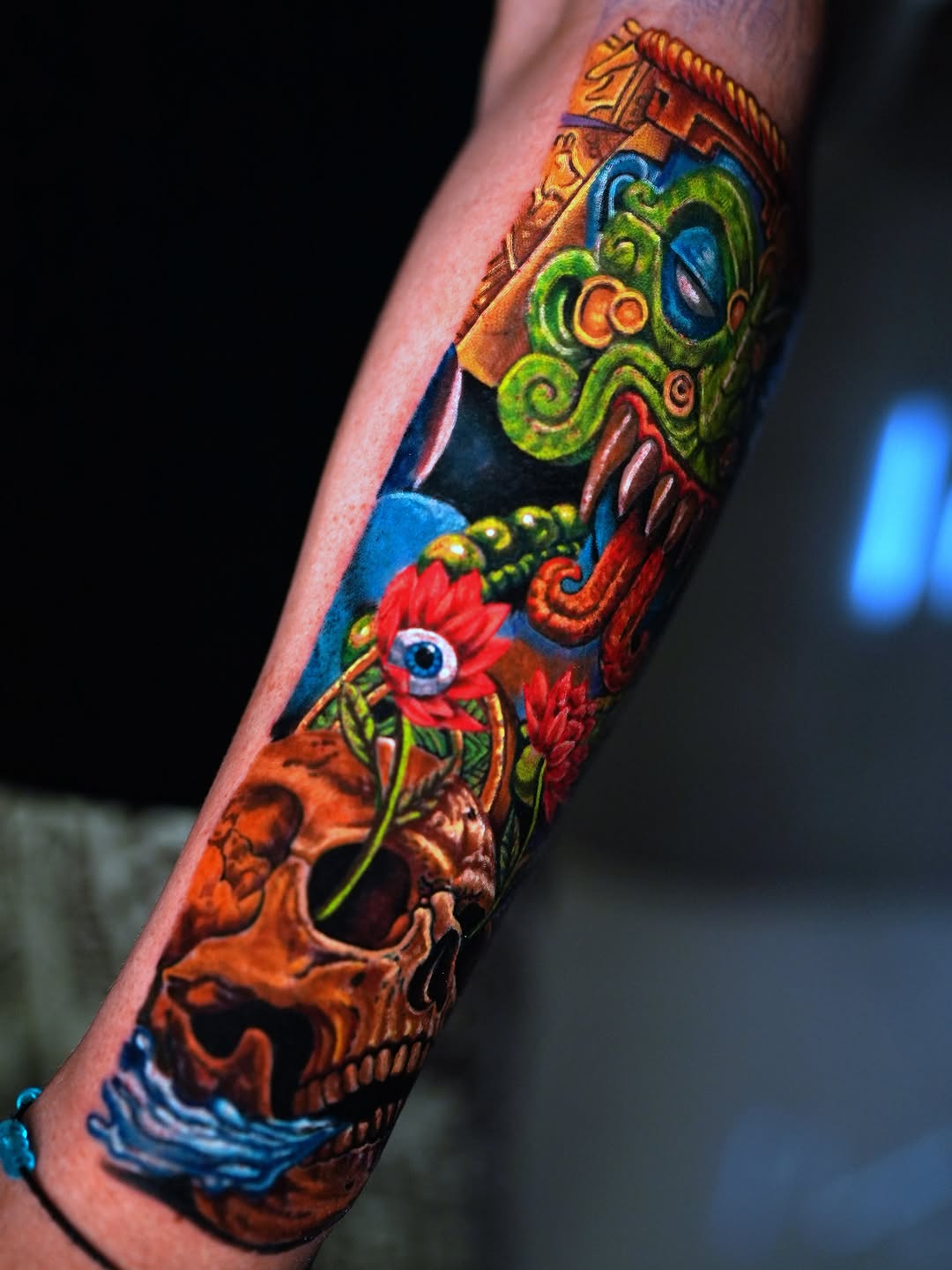 Mayan mask and skull surrealism tattoo on the forearm by Alberto Marrero