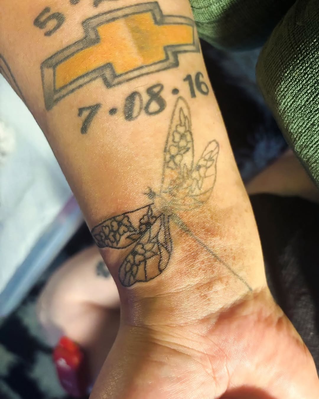 Dragonfly and Chevrolet logo tattoo on the forearm by RVA Tattoo Artist