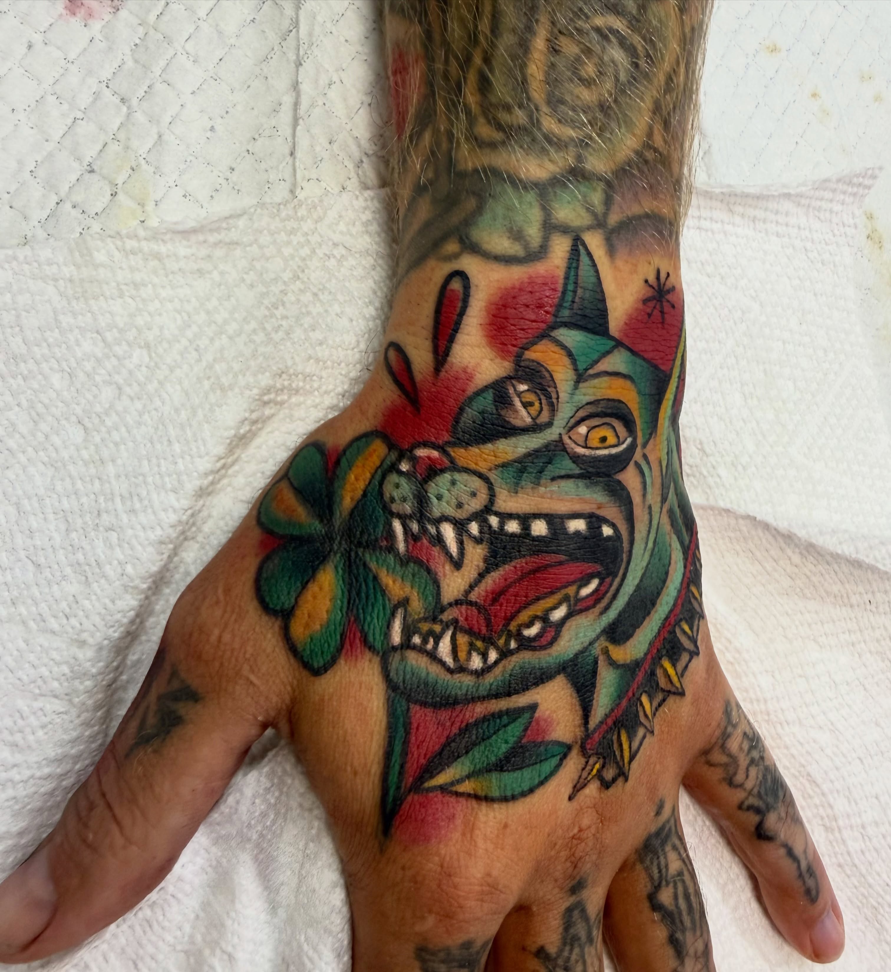 Demon with clover American traditional tattoo on the hand by Shane Bonham