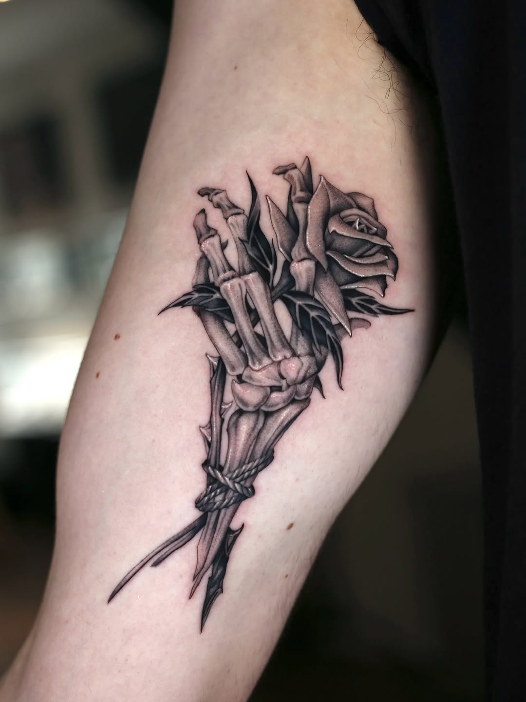 Skeleton hand holding a rose realism tattoo on the forearm by Steve Franciosa