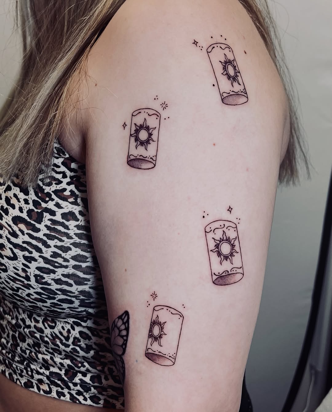 Lanterns with suns minimalist tattoo on the shoulder by vivian