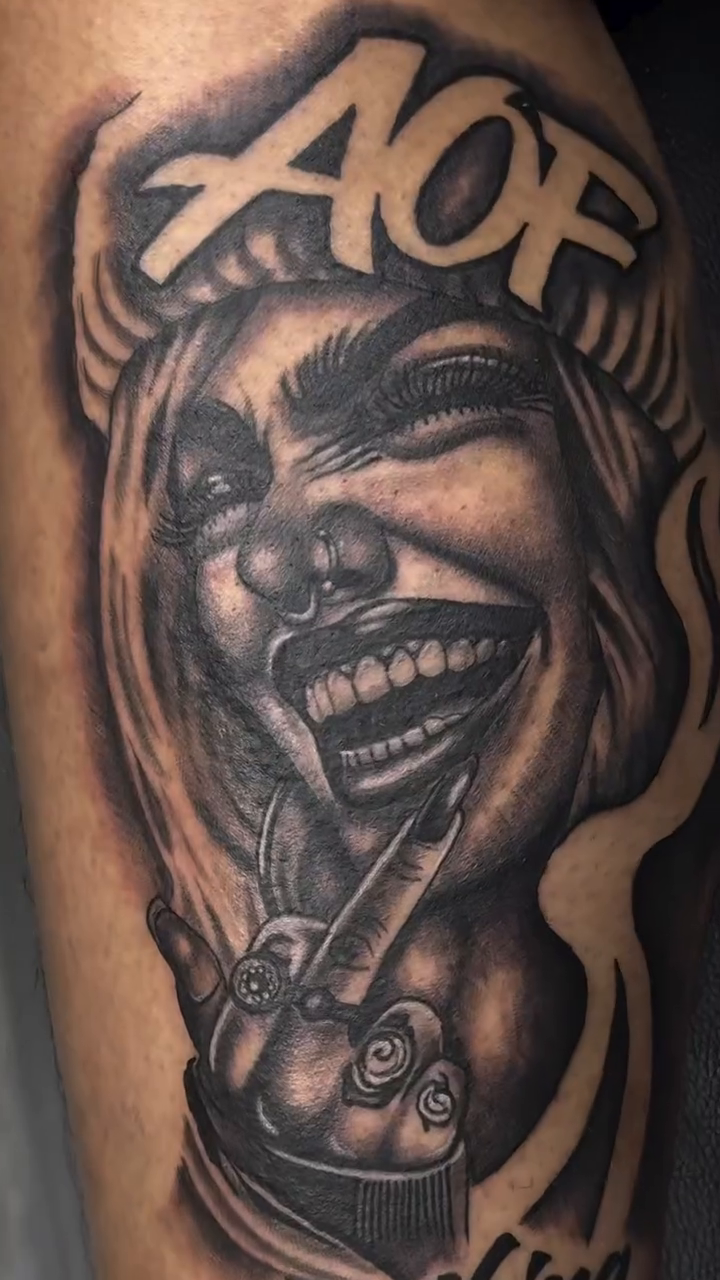 Laughing clown face with text realism tattoo on the forearm by Left My Mark