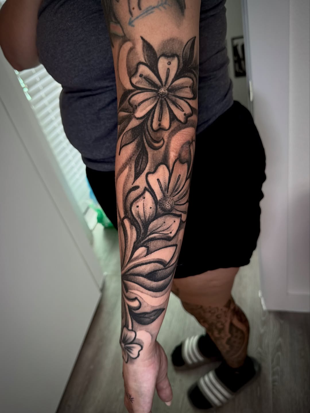 Floral sleeve with swirling background fine line tattoo on the forearm by James ⚡️ Tattoo Artist