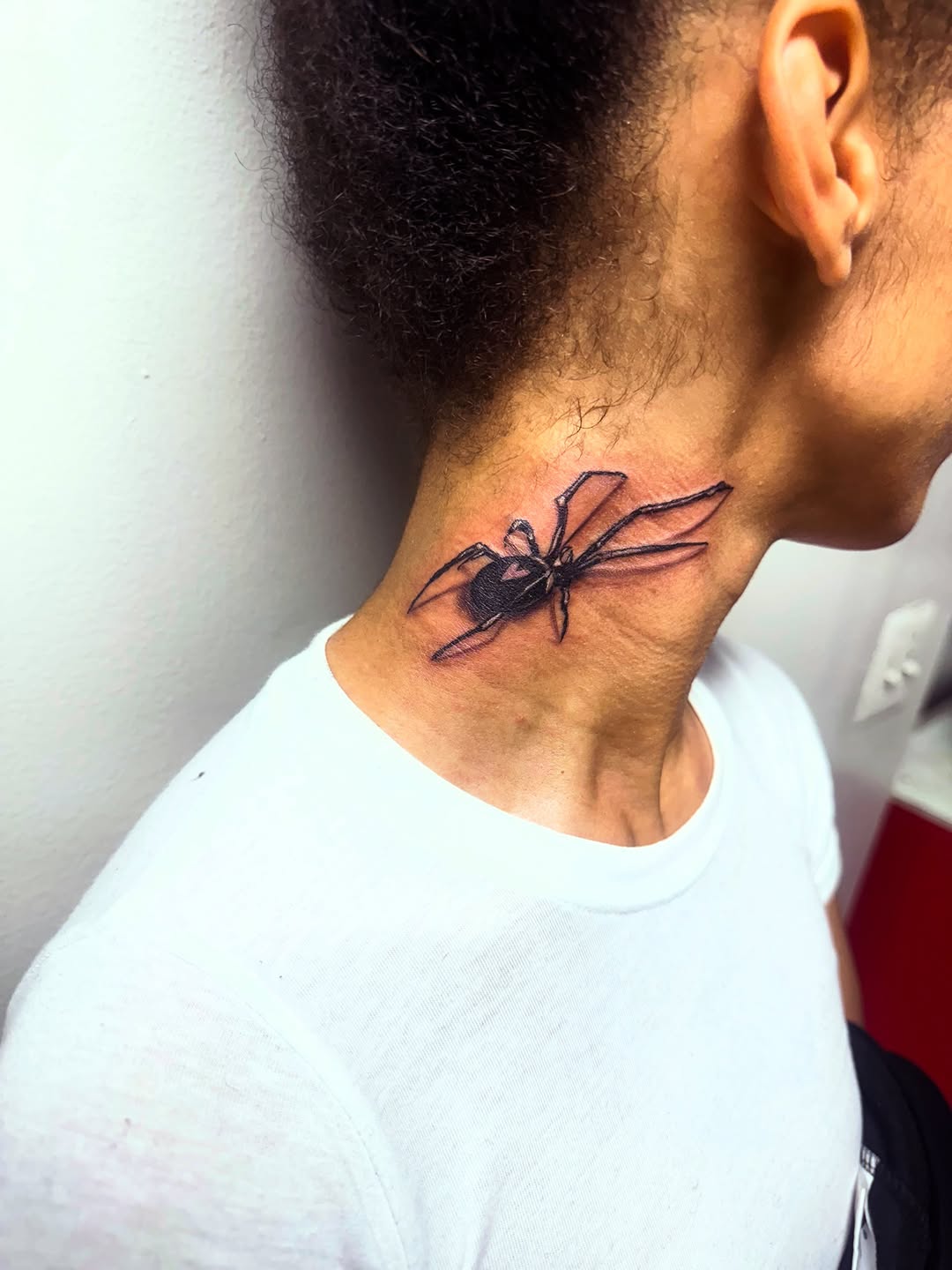 Black widow spider blackwork tattoo on the neck by Uncle Fade Tattoo Artist ✍🏾