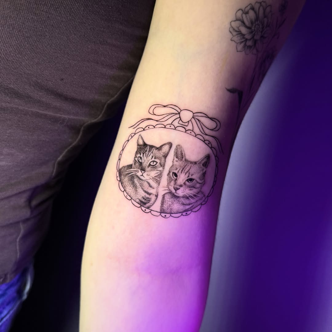 Two cats in a frame realism tattoo on the forearm by Monica Gonzalez