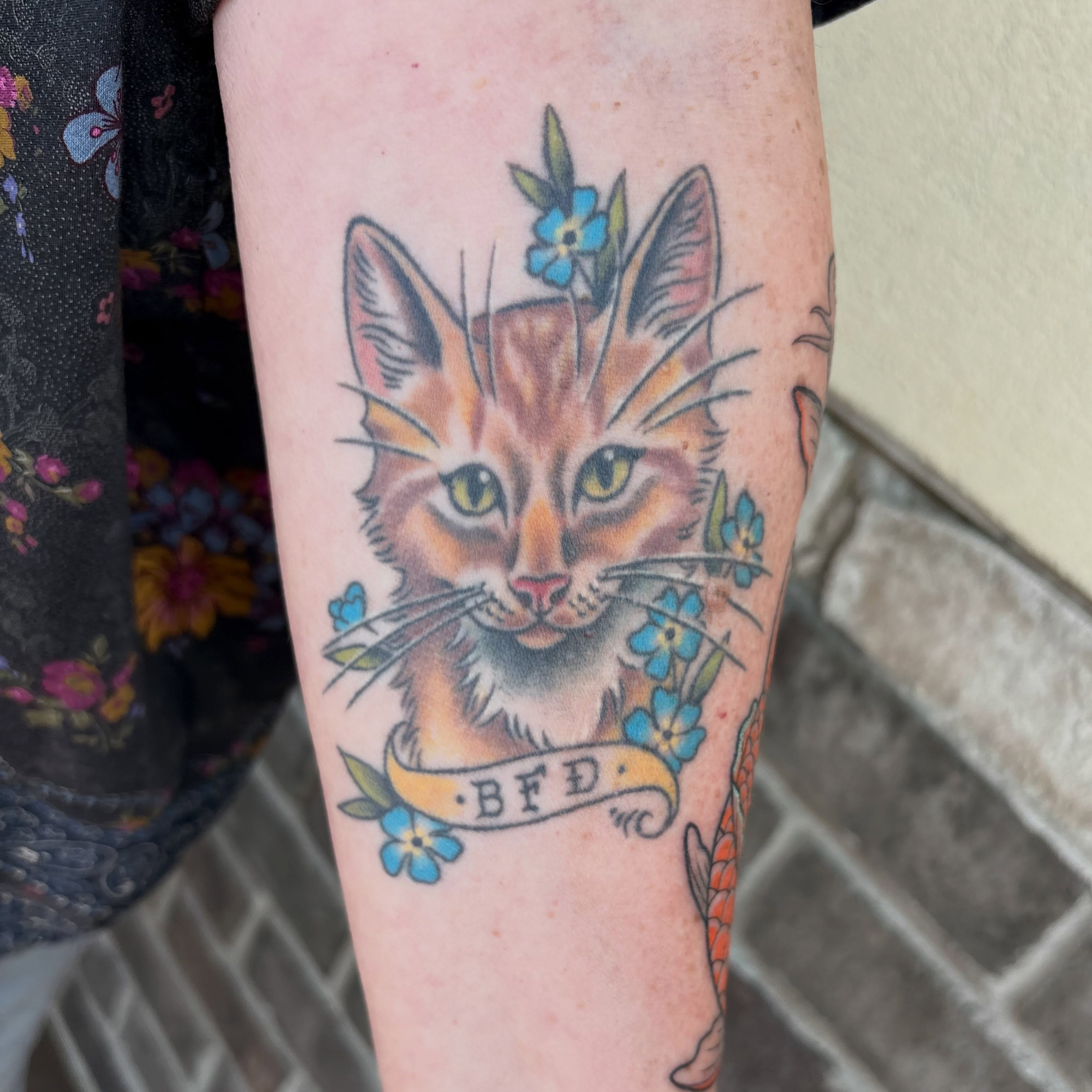 Cat with flowers American traditional tattoo on the forearm by Adriana Wimler