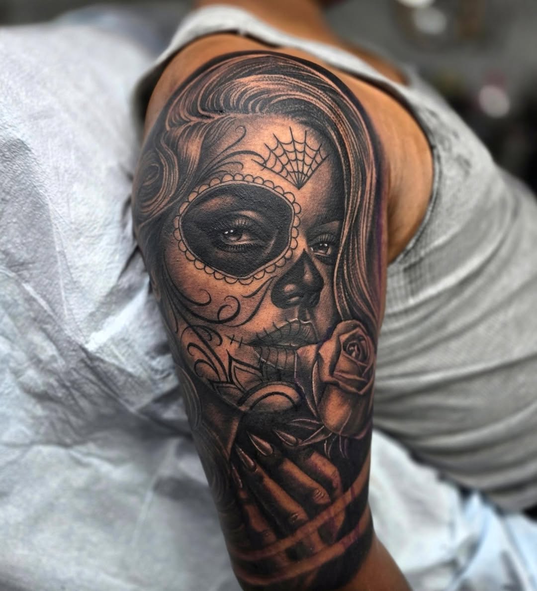 Sugar skull woman with rose realism tattoo on the upper arm by Richie Garcia, Hesperia, California