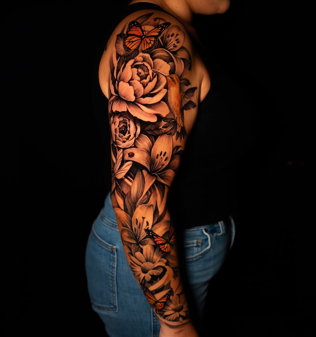 Floral sleeve with butterflies and hummingbird fine line tattoo on the upper arm by Apolo