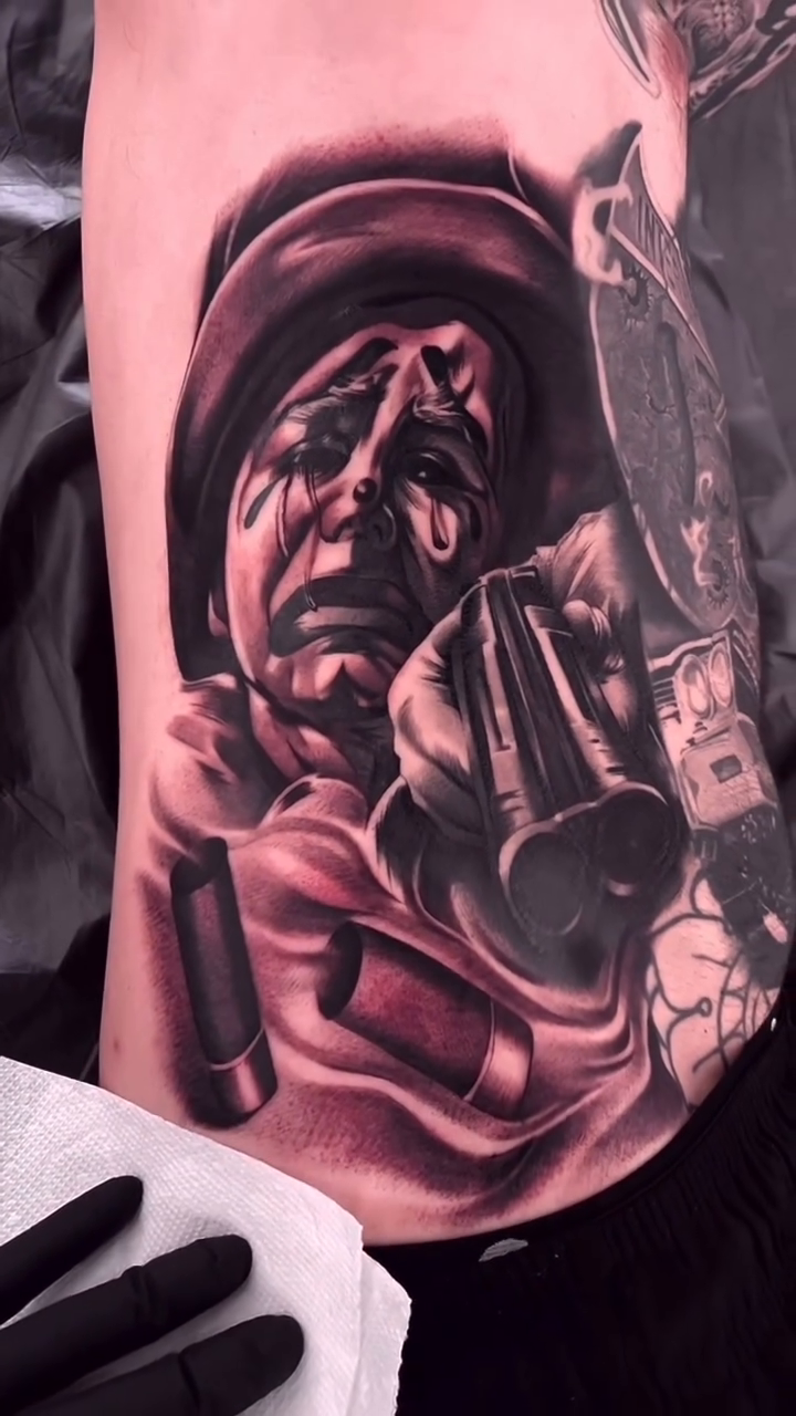 A crying clown with guns realism tattoo on the forearm by Erick Gutierrez, Las Vegas, Nevada
