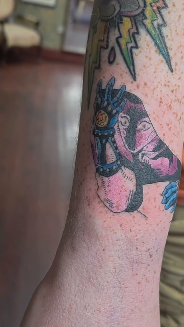 Roller skate with a face tattoo on the forearm by Tattoos by Annie