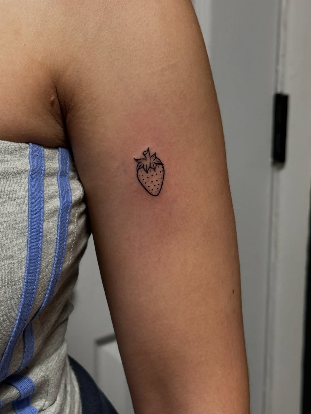 Strawberry minimalist tattoo on the forearm by Jocelyn