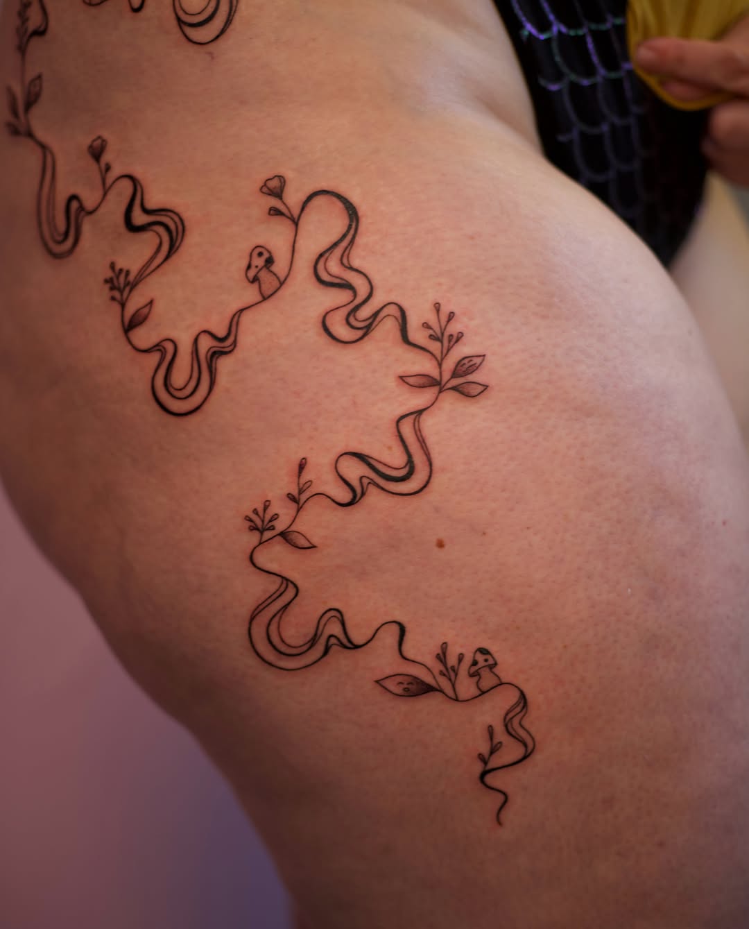 Serpent and flora black and grey tattoo on the thigh by Jess
