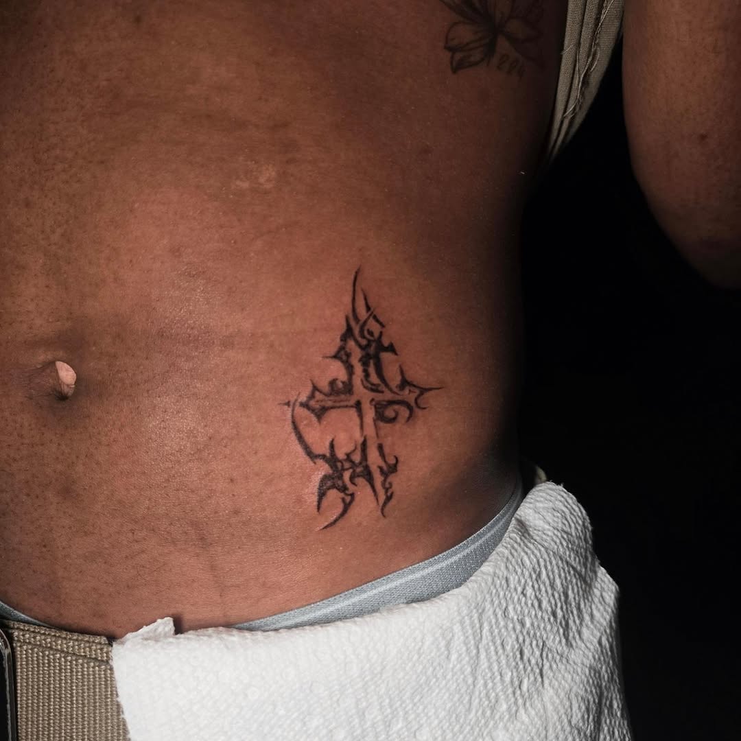 Tribal cross blackwork tattoo on the torso by Scar