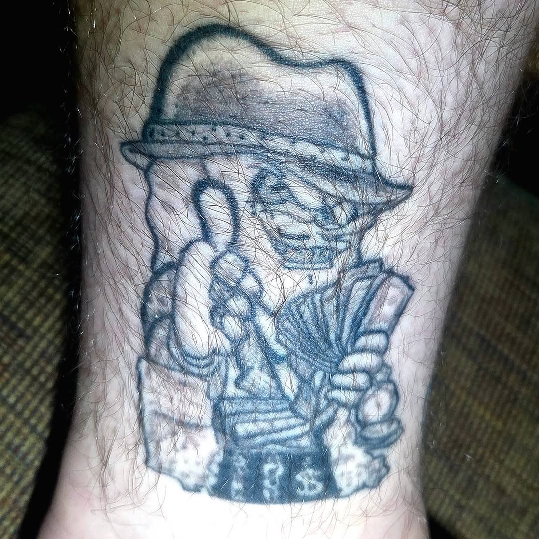 Man in fedora playing accordion ignorant tattoo on the forearm by π«