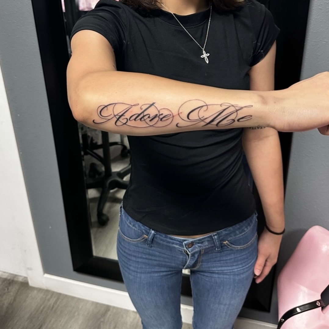 Script lettering lettering tattoo on the forearm by Lupita Ink