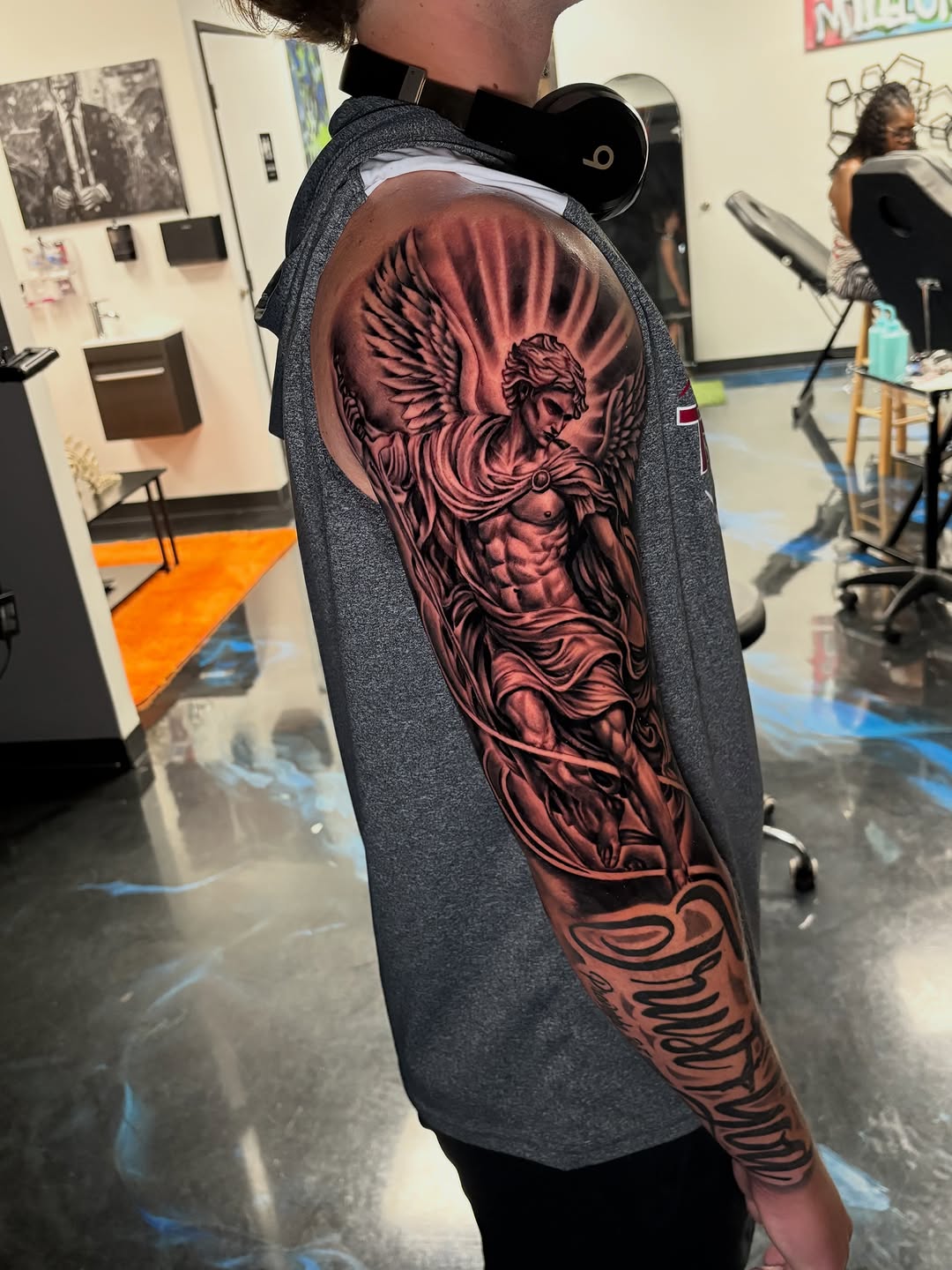 Angel and script lettering realism tattoo on the upper arm by Vonte Seay