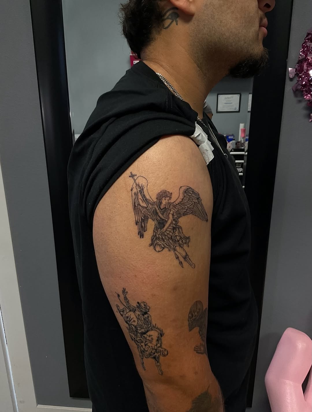 Angel and cowboy riding bull realism tattoo on the upper arm by Lupita Ink