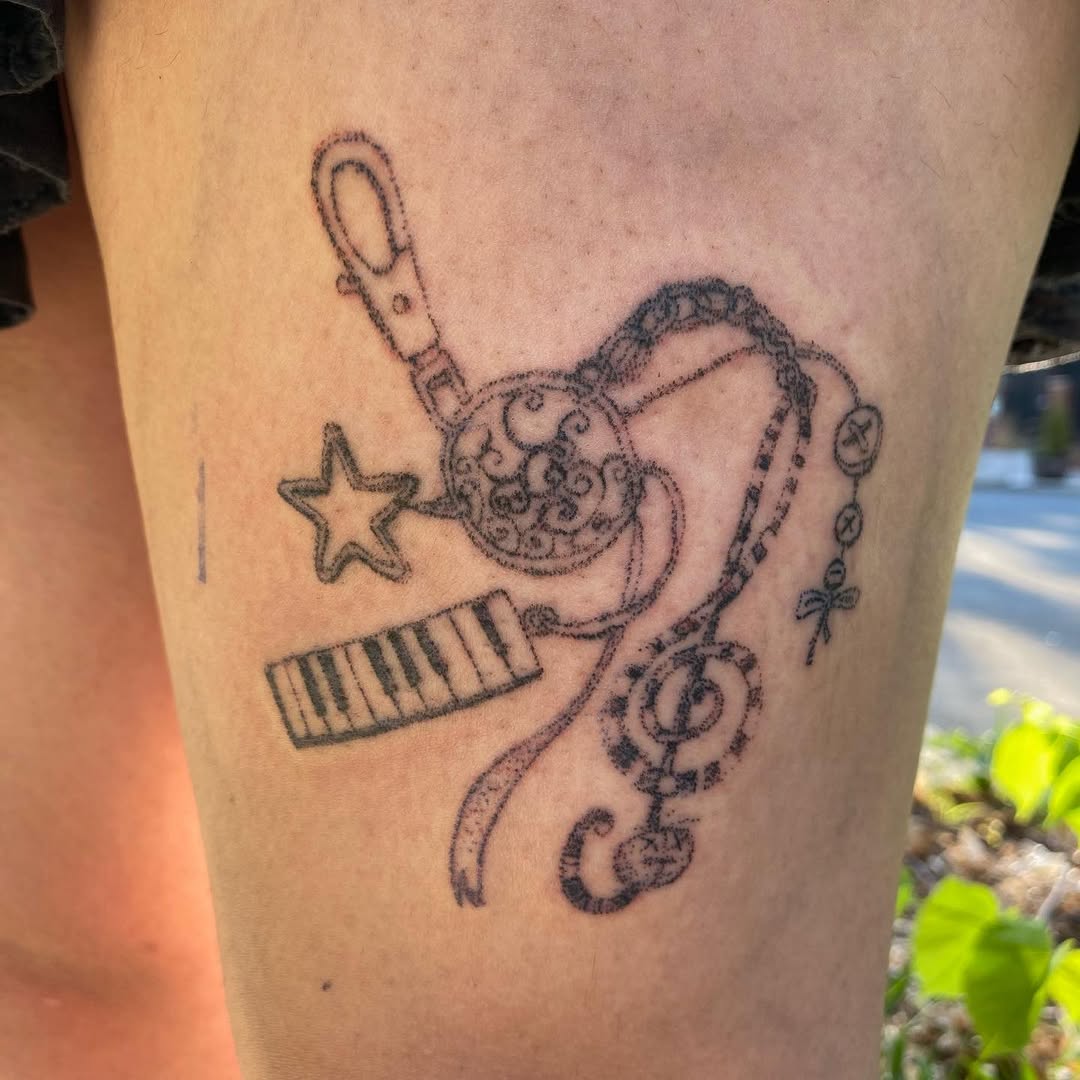 Keychain with musical notes and charms minimalist tattoo on the thigh by @feverfeverish