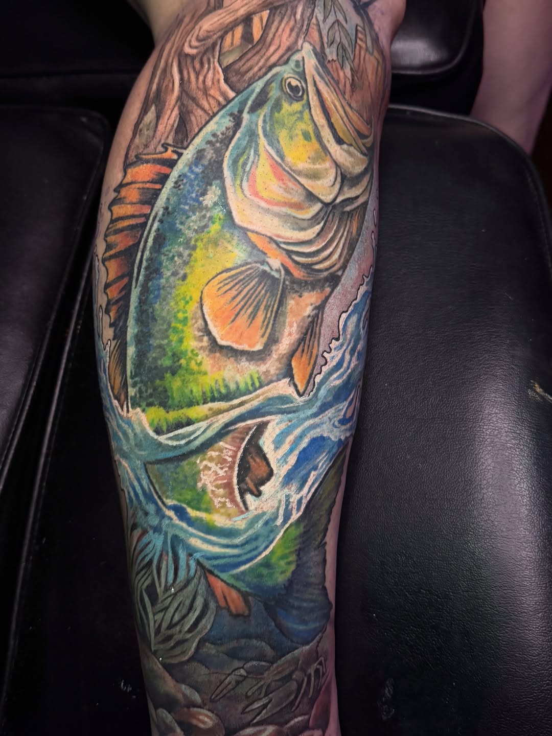 Largemouth bass jumping out of water American traditional tattoo on the forearm by Jarrod Gatzke