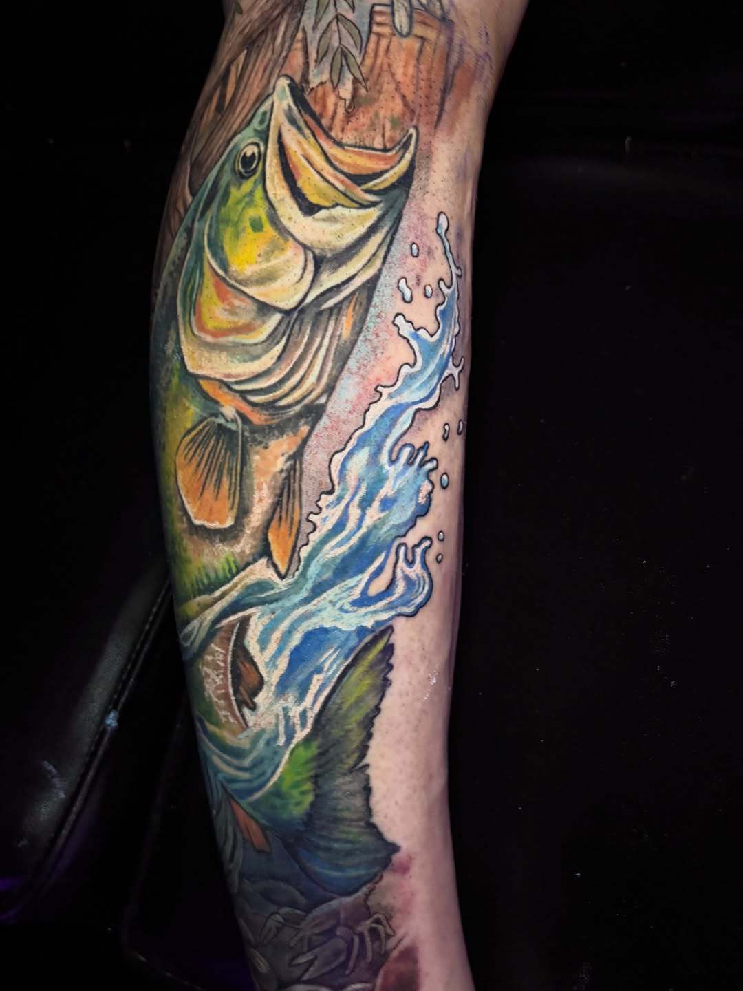 Bass fish jumping out of water American traditional tattoo on the forearm by Jarrod Gatzke