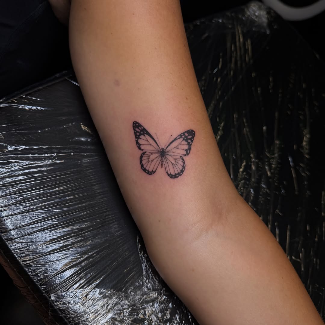 Butterfly fine line tattoo on the forearm by Pretty Ugly Tattoos