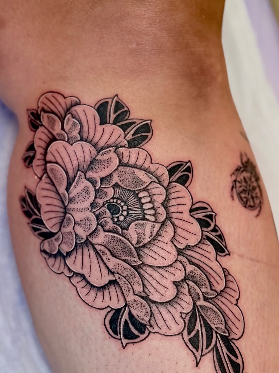 Peony flower dotwork tattoo on the thigh by Ink About Me - Amanda’s Fine Lines