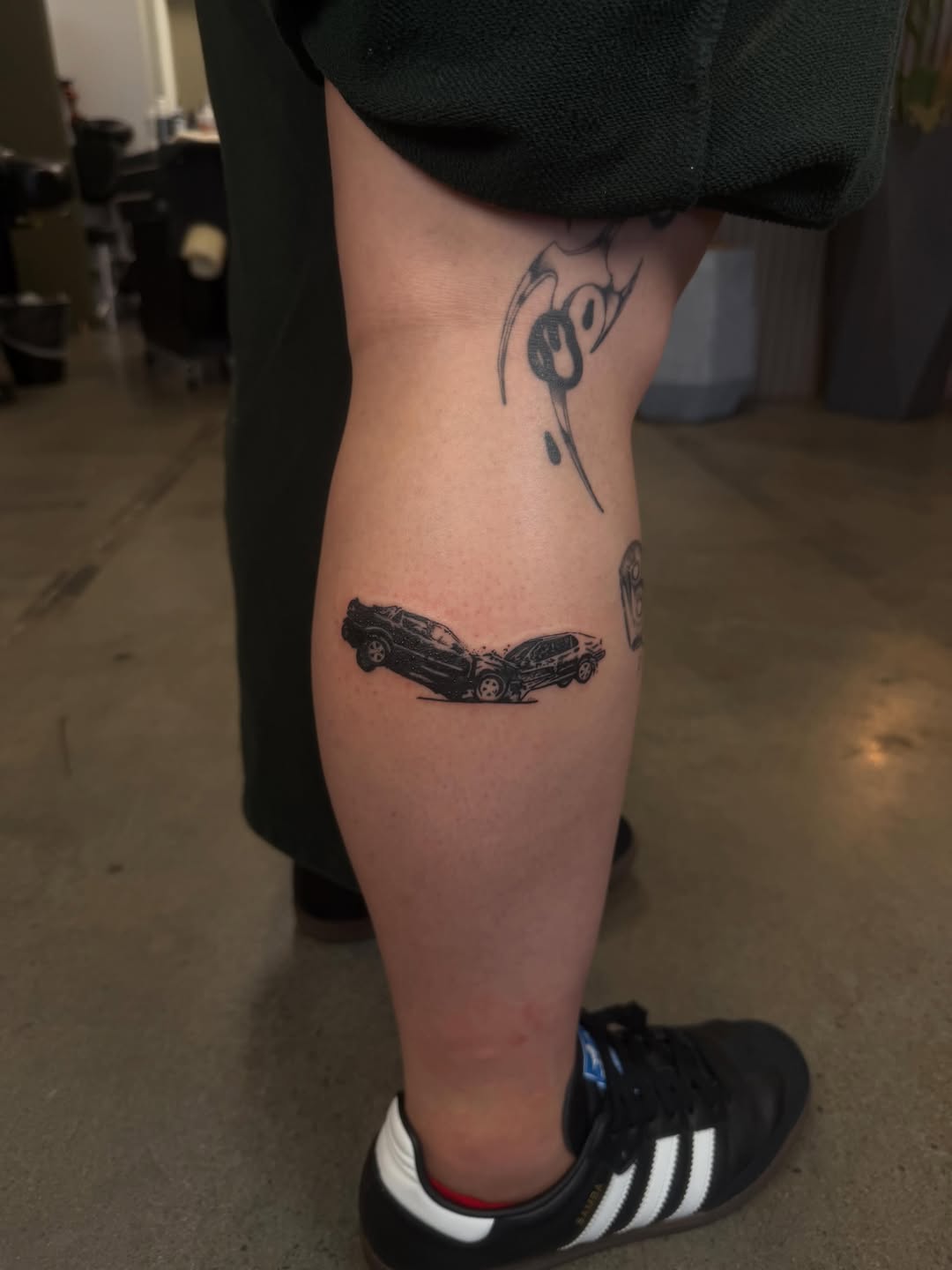Two cars crashing minimalist tattoo on the forearm by Lxx.