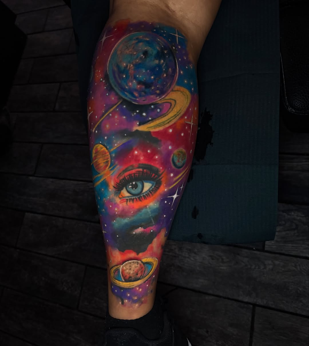 Cosmic eye and planets surrealism tattoo on the calf by Dany