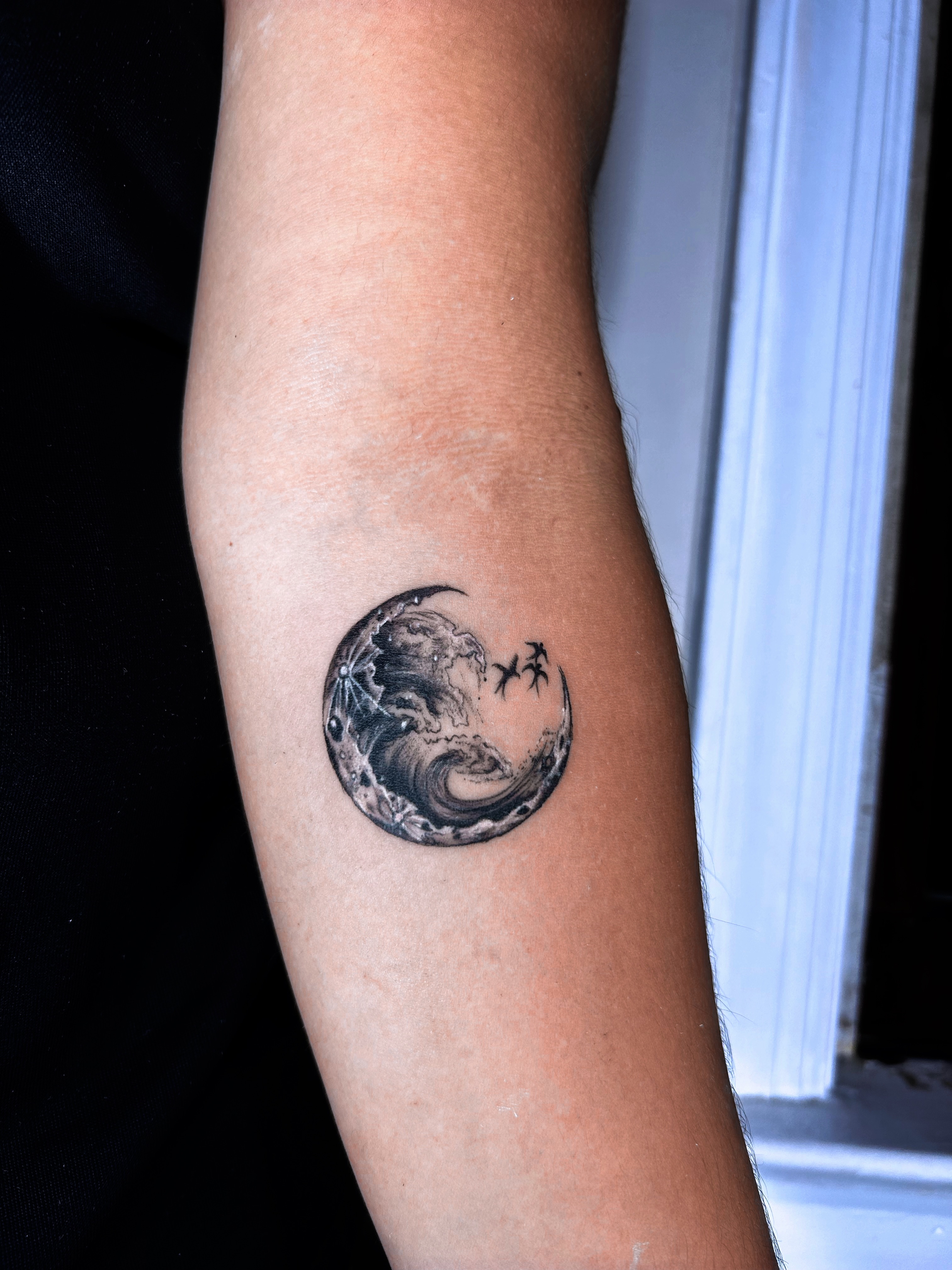 Moon with wave and birds surrealism tattoo on the forearm by Alvaro