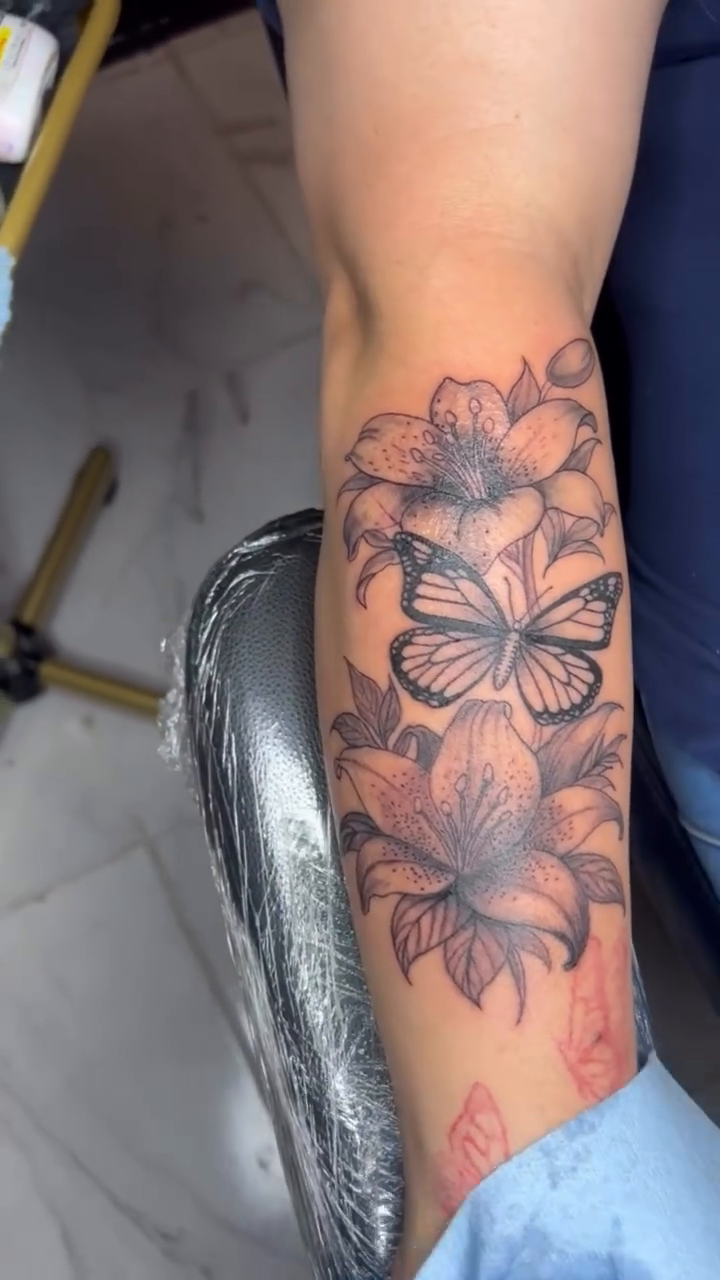 Butterflies and lilies fine line tattoo on the forearm by TP