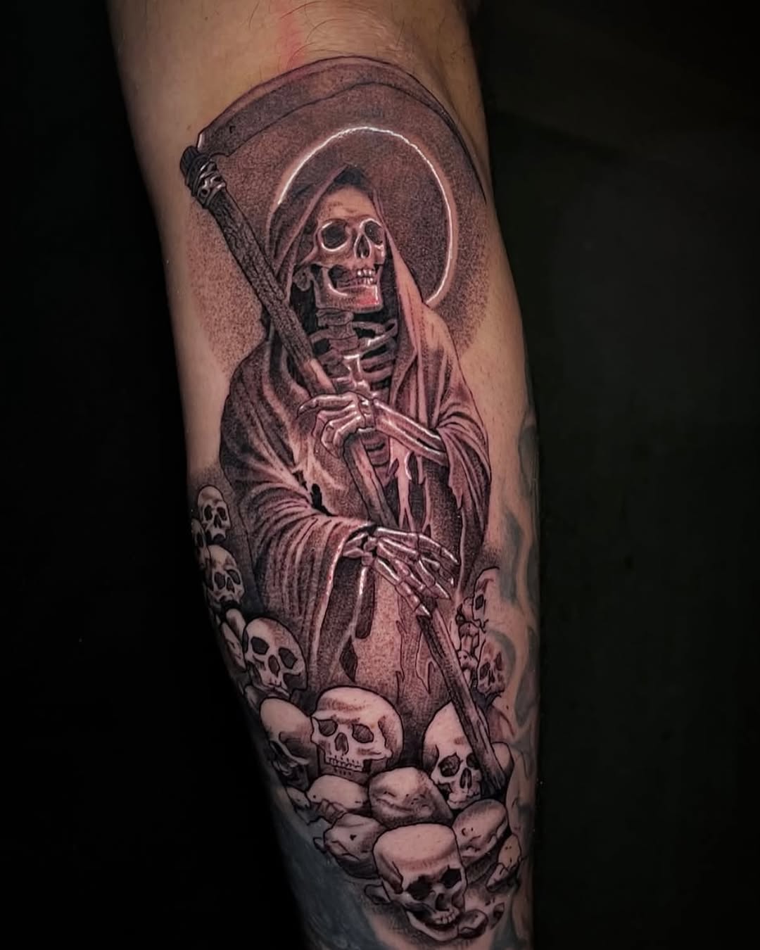 Grim reaper with scythe and skulls realism tattoo on the forearm by Chato