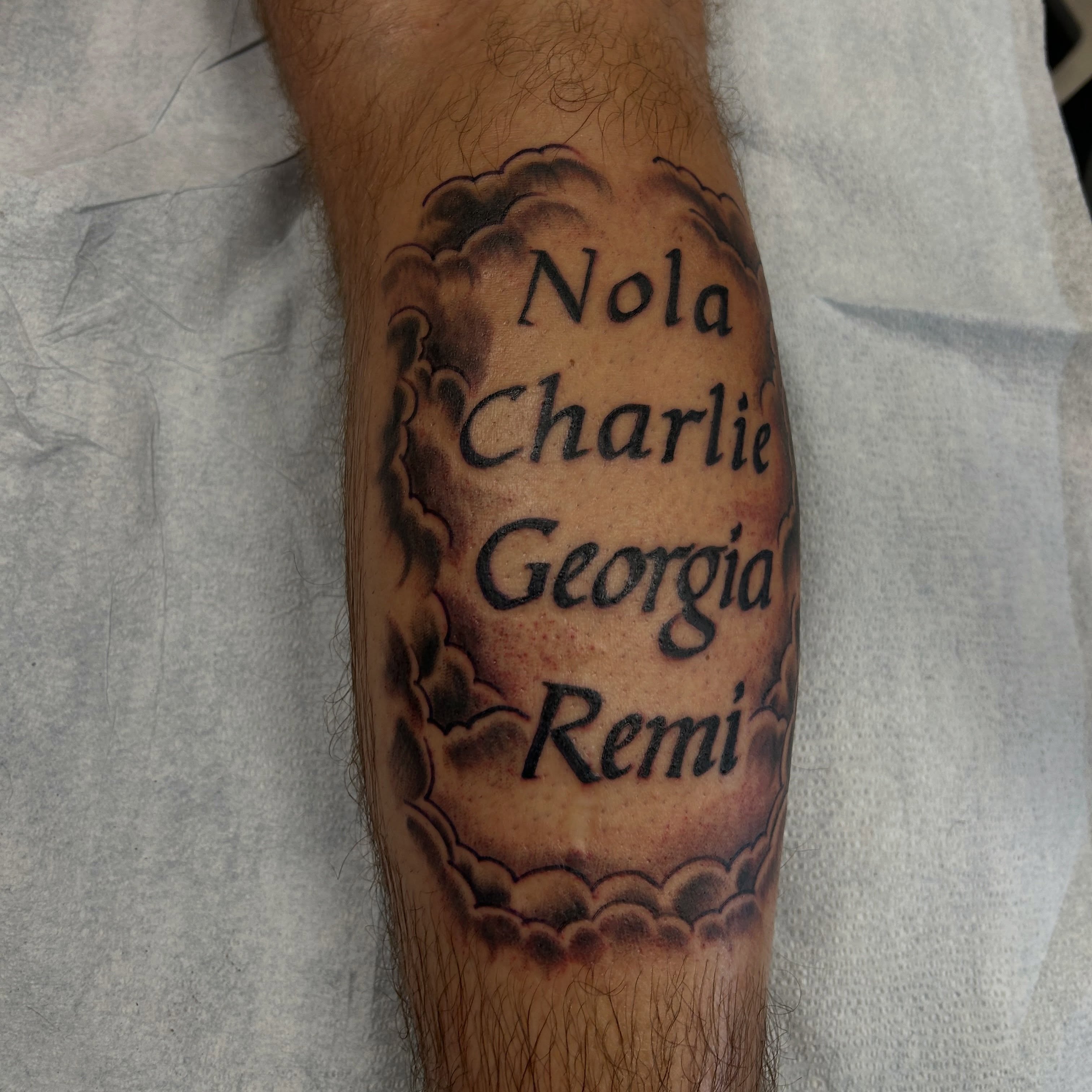 Names lettering script tattoo on the forearm by Erik Sacony
