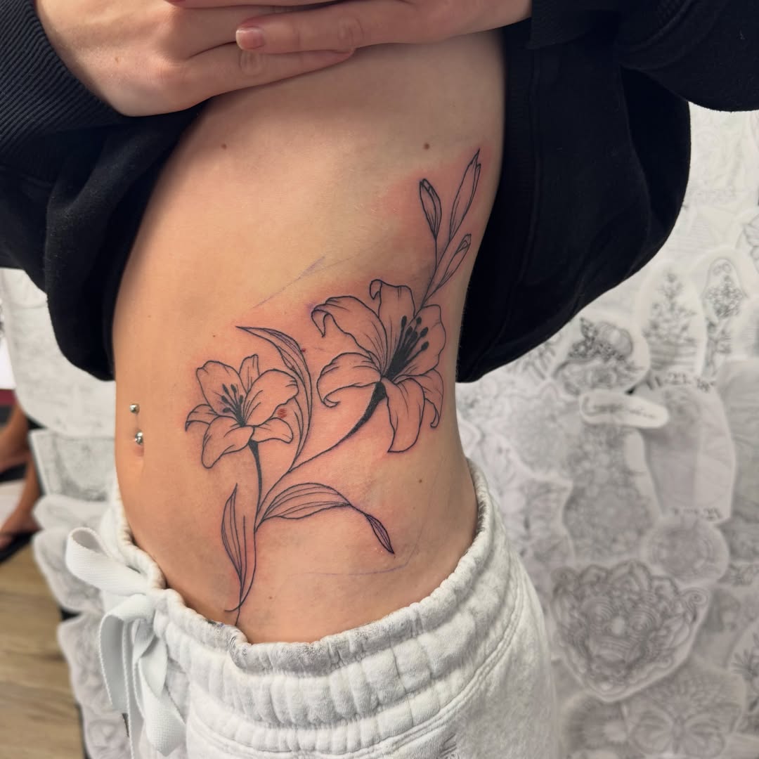 Lilies black and grey tattoo on the ribs by Robbie Bryant
